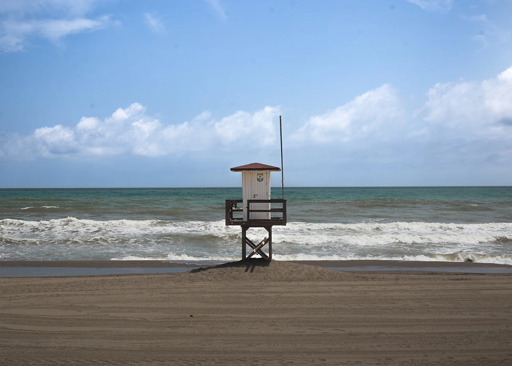 A solitary lifeguard tower overlooking the Mediterranean on a quiet day in Torremolinos.